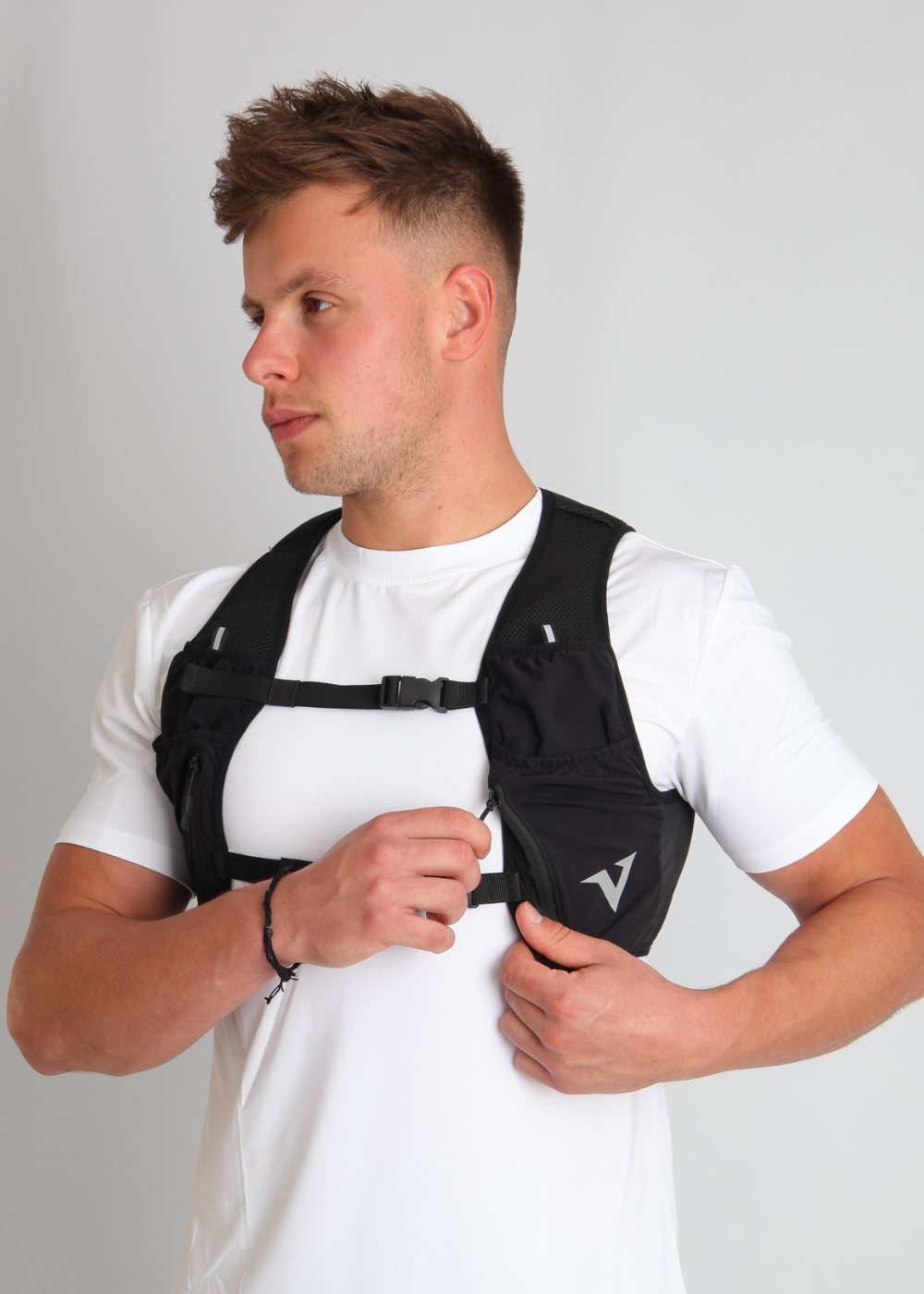 Male runner wearing the Verox Strider-1 running vest on a light grey background, showcasing a lightweight design for road running.