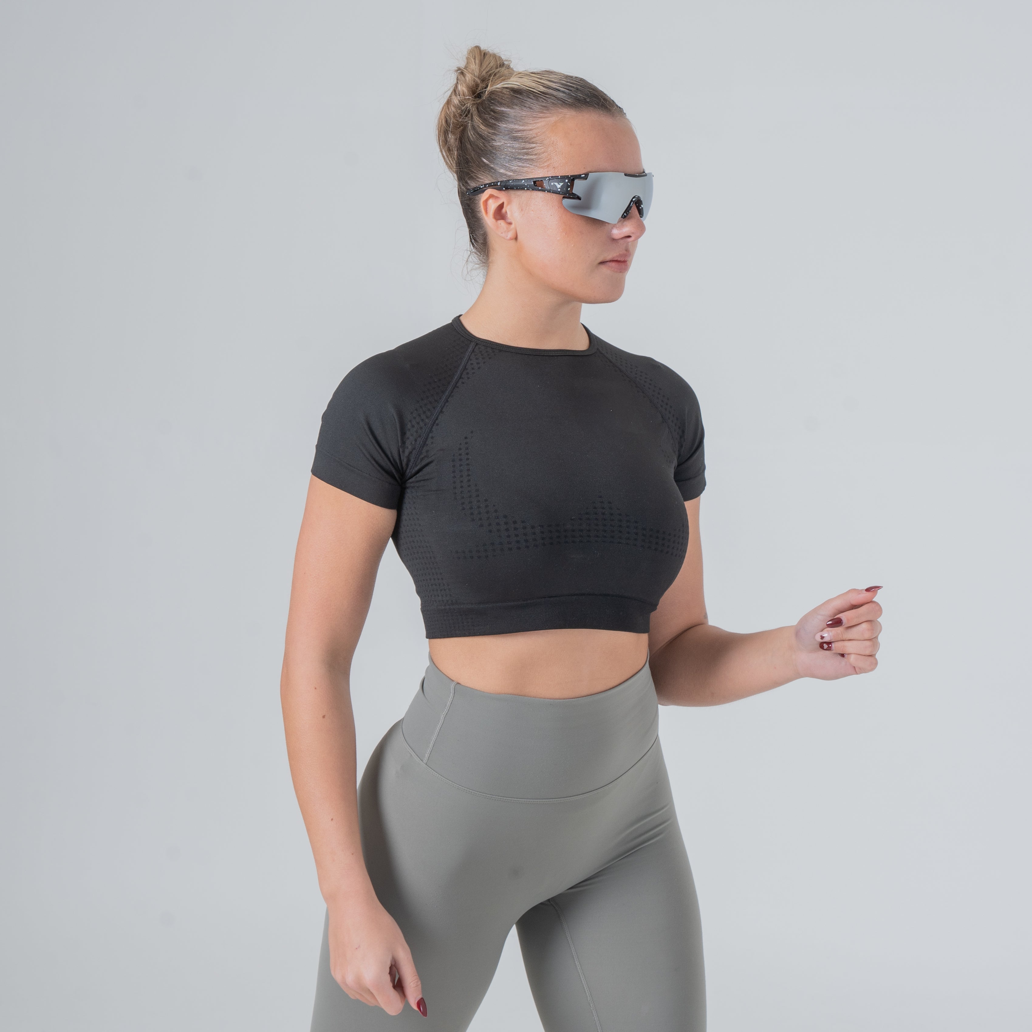 Female model wearing velocity ultra premium polarized sunglasses in a running stance